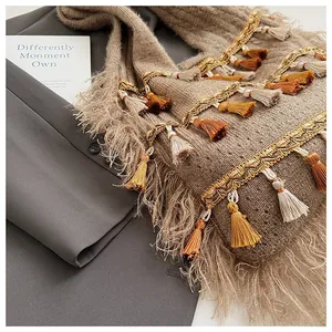 Detailed knit texture and bohemian tassels on a retro oversized hobo shoulder bag