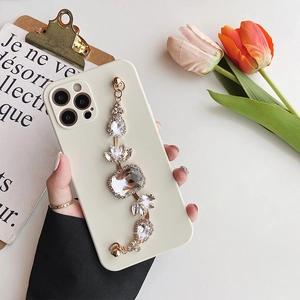 Detail of off-white iPhone case featuring a luxury crystal gemstone hand strap and precision cut