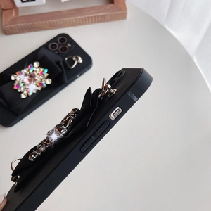 Detail of luxury black iPhone case with 3D fabric bow and inlaid sparkling crystals