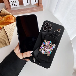 Detail of iPhone case featuring a large black bow with a sparkling pink gemstone