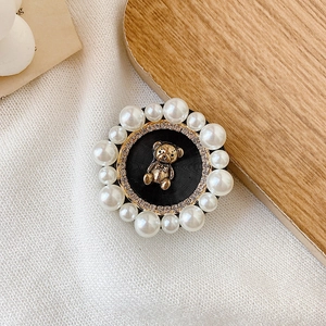 Detailed view of a cute golden bear phone grip with pearl and rhinestone embellishments