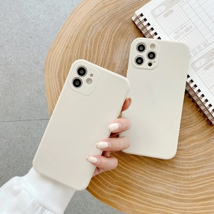 Detail view of cream white liquid silicone phone cases for iPhone on a wooden tray