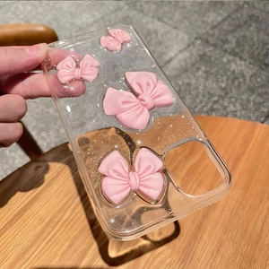 Detail of transparent phone case with pink 3D bows and glitter finish for iPhone
