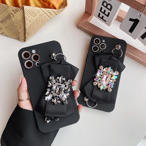 Luxe matte black iPhone 16 Pro Max case with large satin bow and sparkling rhinestones