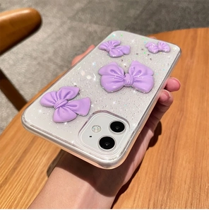Close-up of clear glitter phone case featuring four purple 3D bow relief decorations