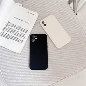 Minimalist matte silicone phone cases in black and cream beige on a textured fabric