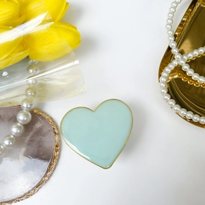 Detail of light green heart phone socket with elegant gold trim on aesthetic background