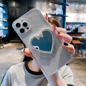 Detail of glittery blue iPhone case featuring a heart-shaped mirror with rhinestone trim
