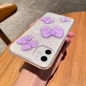 Close-up of purple 3D bows and silver glitter on transparent iPhone phone case