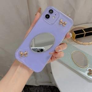 Detail der lila Glitzer-iPhone-Hülle mit goldenen Schleifen und Ovalspiegel