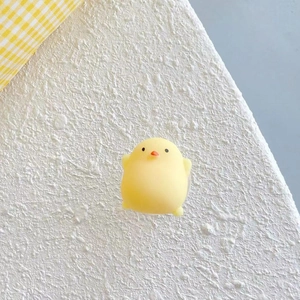 Gros plan d'un support de téléphone poussin jaune mignon pour soulager le stress, fond blanc