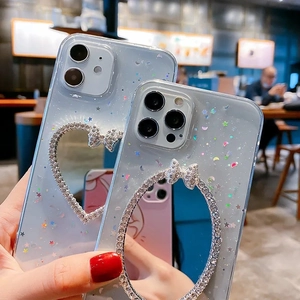 Close-up of clear iPhone case with sparkly sequins, rhinestones, and heart mirrors