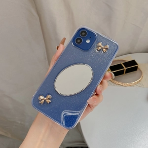 Detail der blauen Glitzer-Hülle mit Spiegel und goldener Schleife für iPhone 16 Pro Max