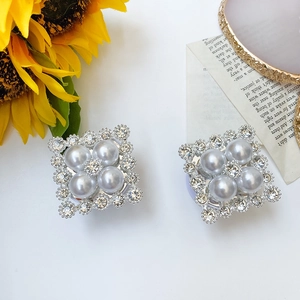 Detailed view of square phone grip with four central pearls and sparkling rhinestone border