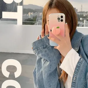 Détail d'un support 3D en forme de pêche rose sur une coque de téléphone dégradée