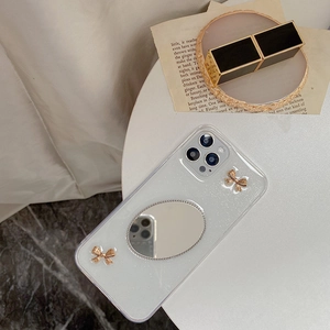 Detailansicht der Glitzer-iPhone-Hülle mit ovalem Spiegel und goldenen Metallschleifen