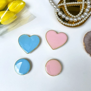 Close-up of heart and round enamel phone grips with gold edges and tulip decoration