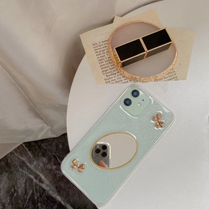 Detail der mintgrünen Glitzer iPhone Hülle mit ovalem Spiegel und goldenen Schleifen