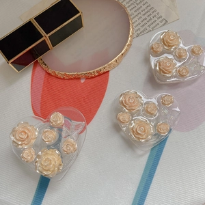 Detailed macro view of vintage heart-shaped phone stands with 3D resin roses and butterflies
