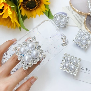 Detail of luxury rhinestone and pearl collapsible phone socket on clear glitter star case