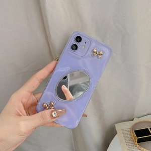 Detail der lavendelfarbenen iPhone-Hülle mit silbernem Schminkspiegel und Gold-Metallschleifen
