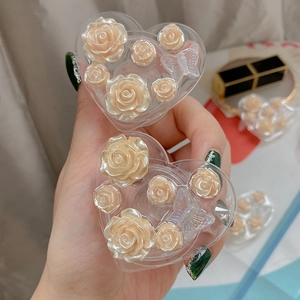 Close-up of heart-shaped phone grip with 3D resin rose and butterfly relief detail
