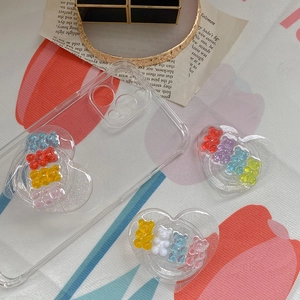 Detail of heart-shaped phone socket with colorful gummy bears and sparkling resin