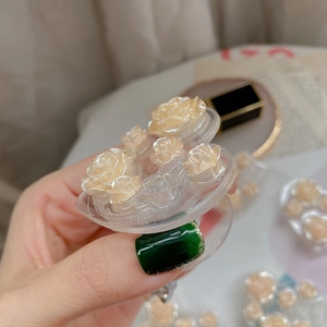 Detailed macro view of 3D cream resin roses on a transparent expanding phone socket grip