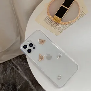 Detail of glitter iPhone case featuring golden rhinestone butterflies and crystal accents