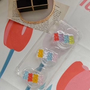Close-up of heart-shaped phone grips with colorful gummy bears on a clear case