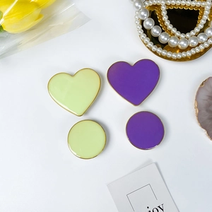 Flat lay of heart and round drip glue phone grips with gold edges and tulip decor