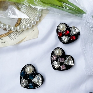 Detailed view of heart-shaped rhinestone phone grips with pearls and colorful crystals