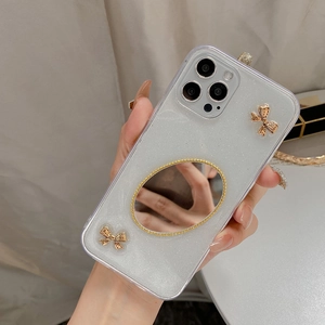 Detail der Glitzer-iPhone-Hülle mit ovalem Schminkspiegel und goldenen 3D-Schleifen