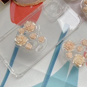 Detail of 3D resin roses and iridescent butterflies on a heart-shaped phone stand