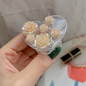 Detail view of heart-shaped phone grip with resin roses and a holographic butterfly