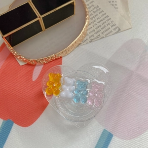 Macro detail of heart-shaped glitter phone grip with colorful resin bear charms
