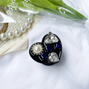 Close-up of heart-shaped luxury phone grip with sparkling rhinestones and pearls