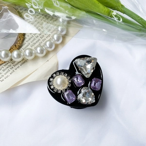 Detail of luxury heart phone grip with pearl and rhinestones on elegant silk background
