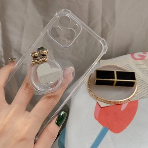 Detail of transparent phone case with heart mirror and cute golden bear accents