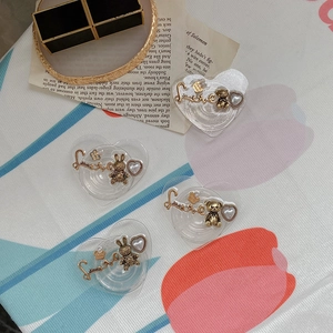 Close-up of retro heart-shaped phone grip with gold Love font and pearl bear charms