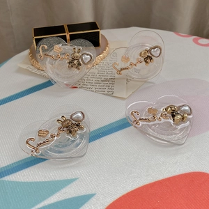 Macro view of four DIY heart-shaped phone grips with gold bears and pearl accents