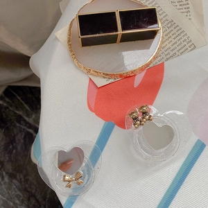 Detailed view of heart-shaped acrylic phone grips with golden bear and bow accents