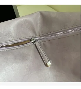 Detail of smooth metal zipper and lychee pattern texture on lavender purple tote bag