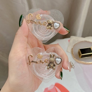 Macro view of heart-shaped glitter phone grips with vintage bear and rabbit charms