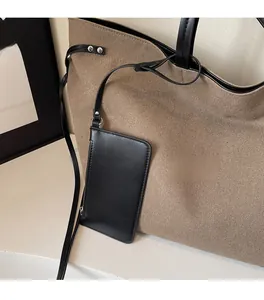 Dettaglio della borsa tote in tela con tracolla in pelle e astuccio coordinato