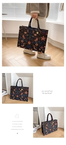 Detail of vintage tote bag with red floral bird embroidery and golden brand tag