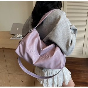 Detail of light purple leather tote bag with LOVE 105 embossed design and shoulder strap