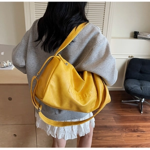 Detail of a large yellow tote bag with LOW 05°C embossed texture and soft PU leather