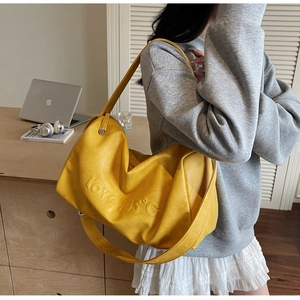 Yellow large capacity shoulder bag with love 105 embossed design worn by model