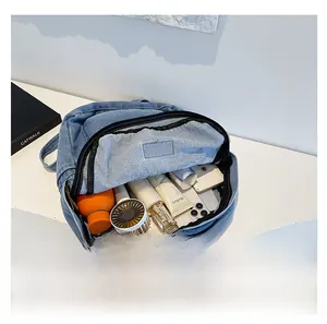 Internal view of the blue denim backpack showing large storage for daily essentials